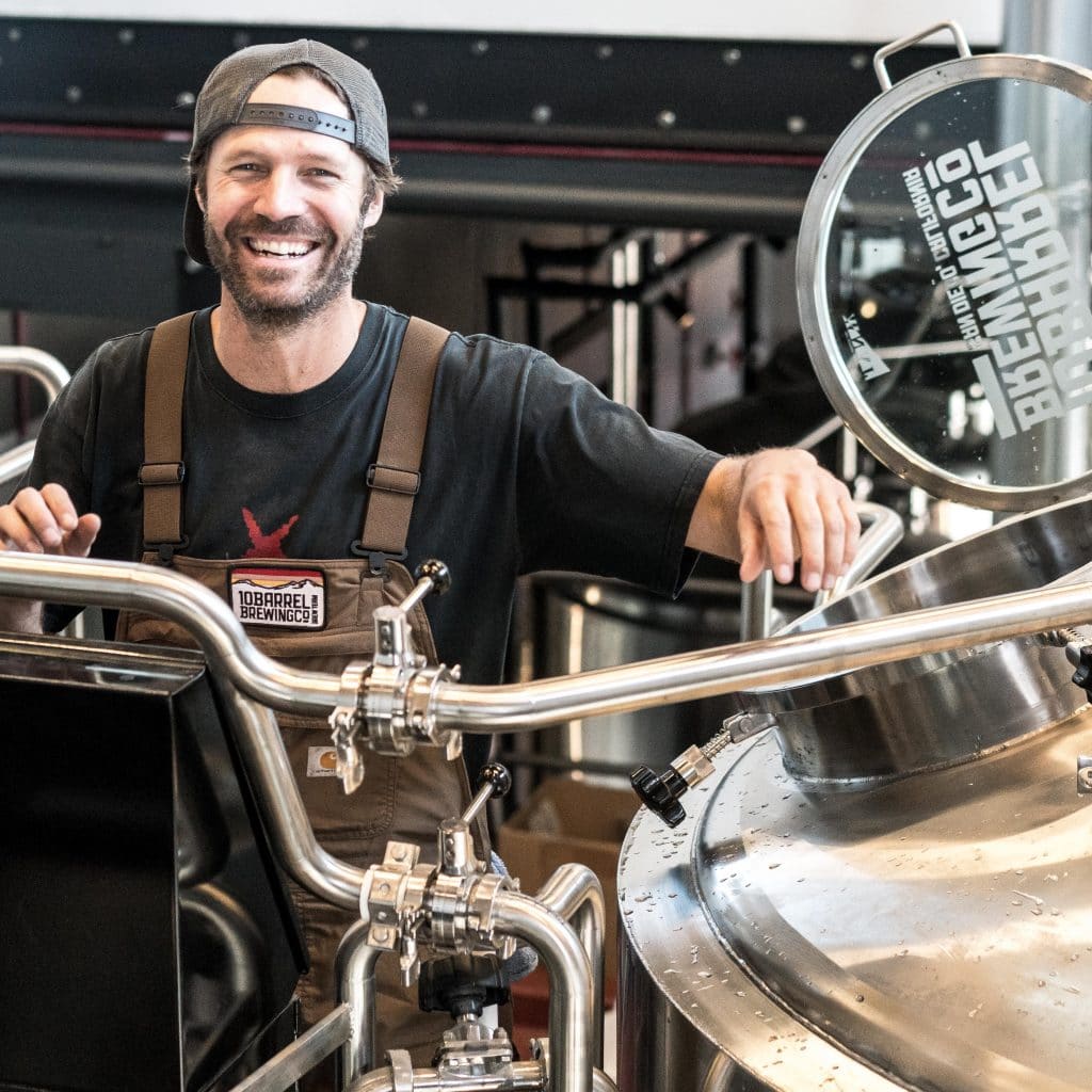 Smiling man with brewing equipment, showing a small business owner in need of an accountant