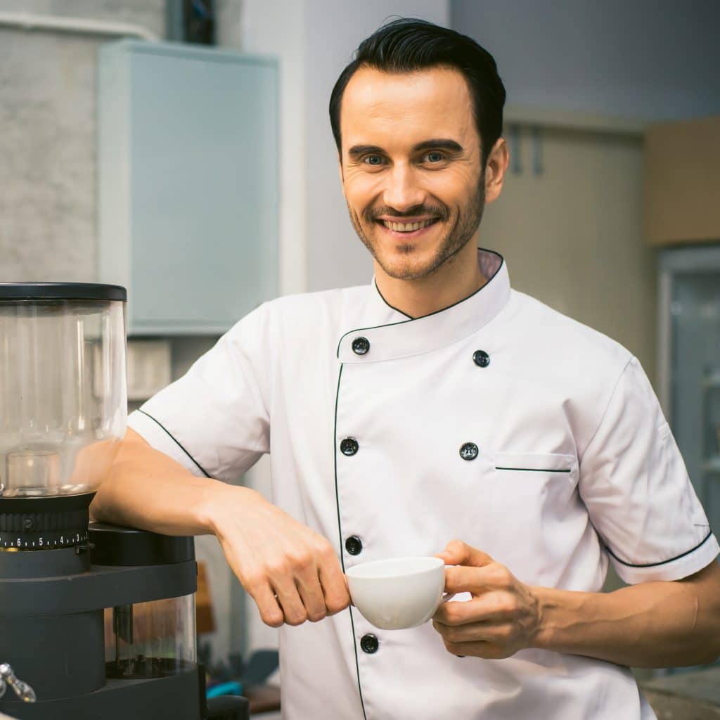 Smiling cafe working holding a coffee mug, showing the need for a small business accountant in Victoria