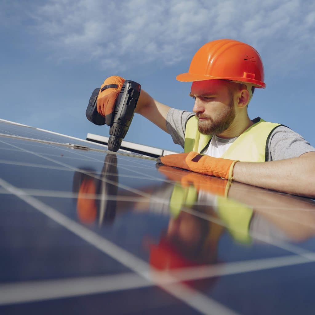 Tradesman with a hard hat installing solar panels, representing the need for a tradies accounting in Victoria